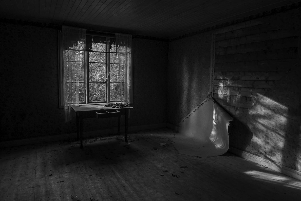 desk by window in abandoned house