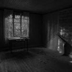 desk by window in abandoned house