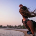 woman with brown hair in car during sunset