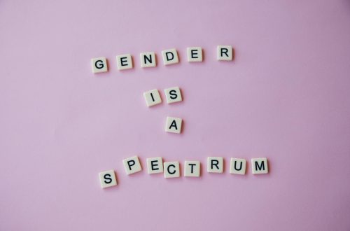 inscription gender is a spectrum made of scrabble letters against pink background