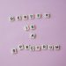 inscription gender is a spectrum made of scrabble letters against pink background
