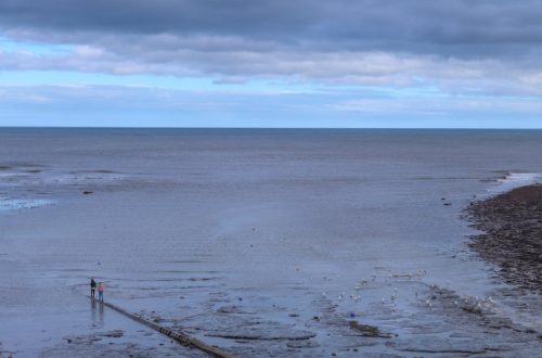 view of the beach and sea under a cloudy sky