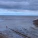 view of the beach and sea under a cloudy sky
