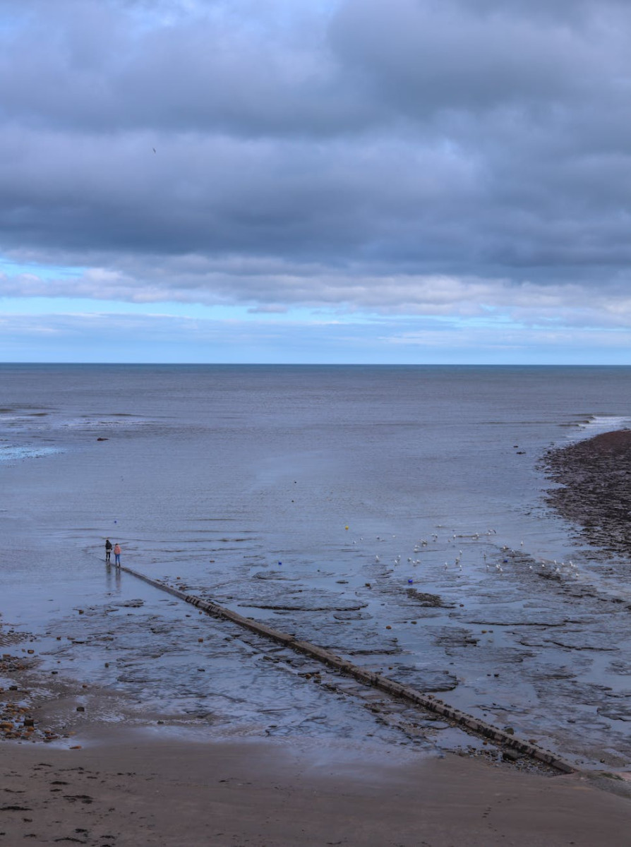 view of the beach and sea under a cloudy sky