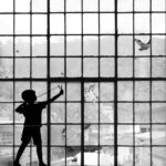 silhouette of person standing in front of window