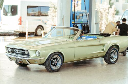 a vintage convertible car parked on the gasoline station