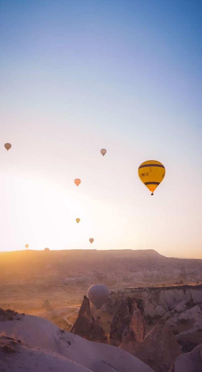 hot air balloons in the sky during sunset
